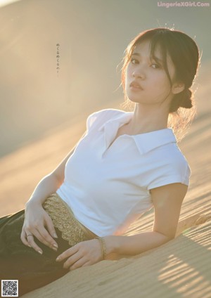 A woman in a white shirt is posing for a picture.