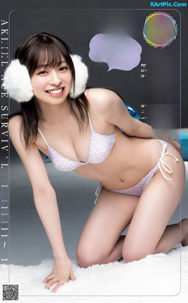 A woman in a white bikini and ear muffs posing for a picture.