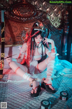 A woman in a white lingerie sitting on a bed.