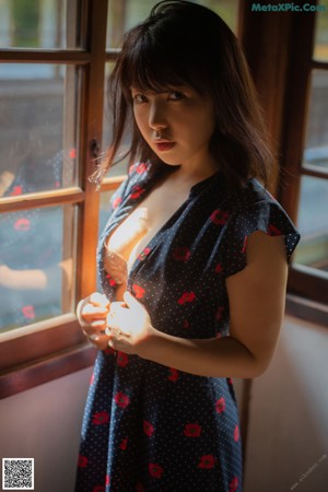 A woman in a polka dot dress leaning against a railing.