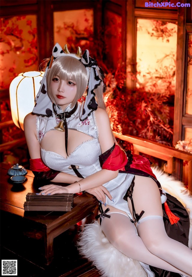 A woman in a maid outfit sitting on a table.