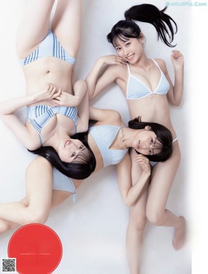 A woman in a blue and white striped bikini posing for a magazine.