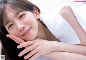 A woman in a white shirt looking up at the sky.