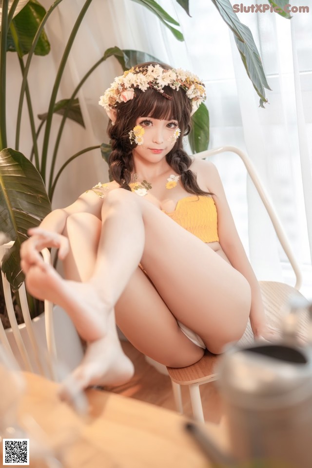 A woman in a yellow bikini sitting on a chair.
