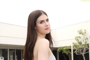 A woman in a black bra posing by a pool.