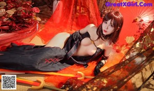 A woman in a black and red outfit holding a sword.