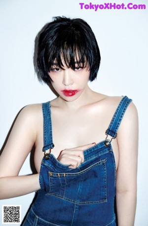 A woman in a white shirt and black shorts sitting on the floor.