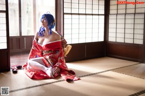 A woman in a red kimono sitting on a red couch.