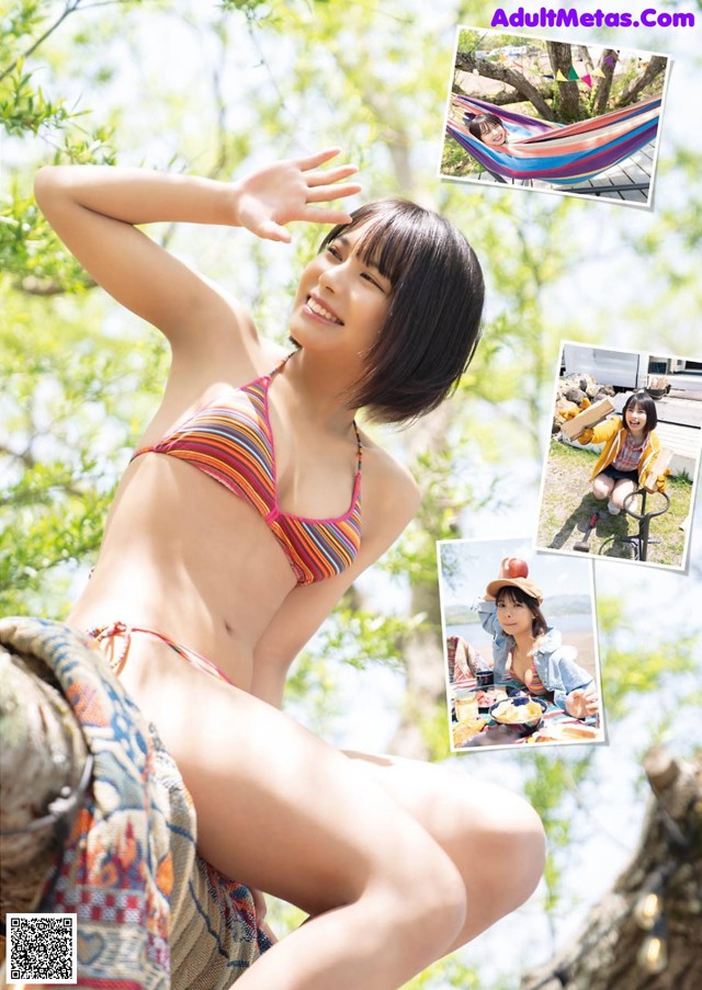 A woman in a bikini sitting on a tree branch.