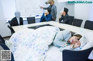A person laying on a blanket with a teddy bear.