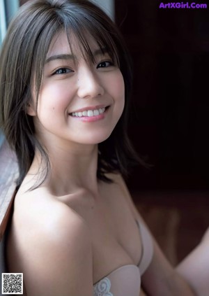 A woman in a swimming pool smiling at the camera.