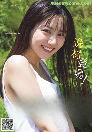 A young woman wearing a white top and blue polka dot shorts.