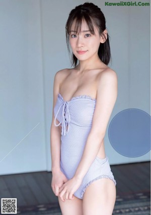 A woman in a purple bathing suit posing for the camera.