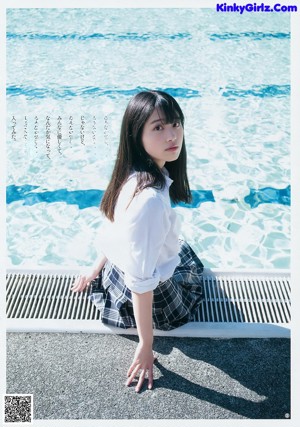 A woman in a white shirt and blue shorts posing for a magazine.