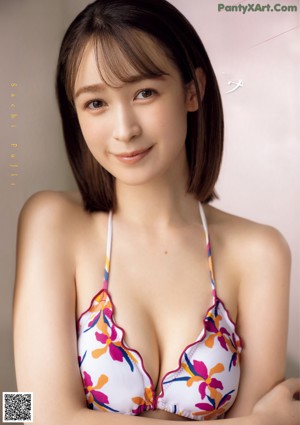 A woman in a yellow bikini posing for a picture.
