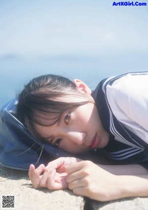 A woman in a blue and white striped dress posing for a magazine.