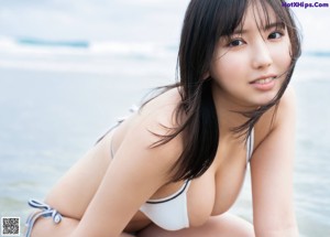 A woman in a bikini standing on a beach.