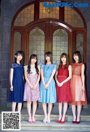 A group of women standing next to each other in front of a building.