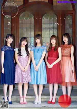 A group of young women sitting on top of a bed.