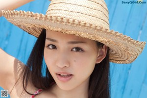 A woman in a pink bikini sitting on a yellow chair.