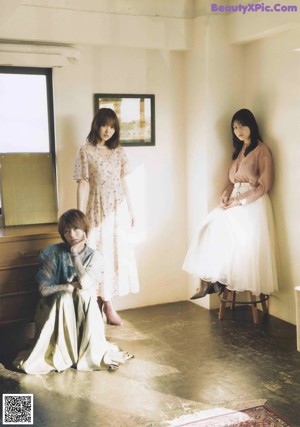 A group of three young women standing next to each other.