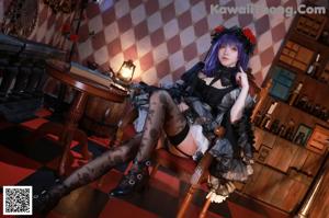 A woman with purple hair sitting on a chair.